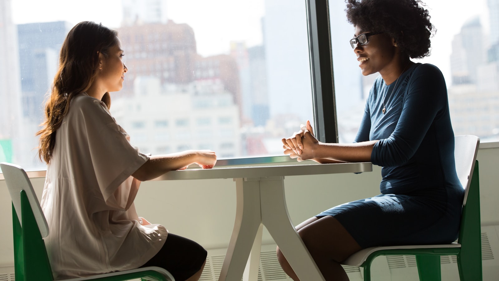Two colleagues having a relaxed conversation across a table
