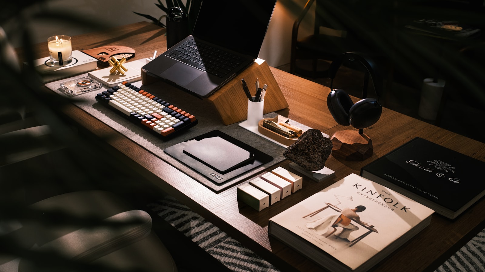 A tidy desk with an open laptop and a small stack of books